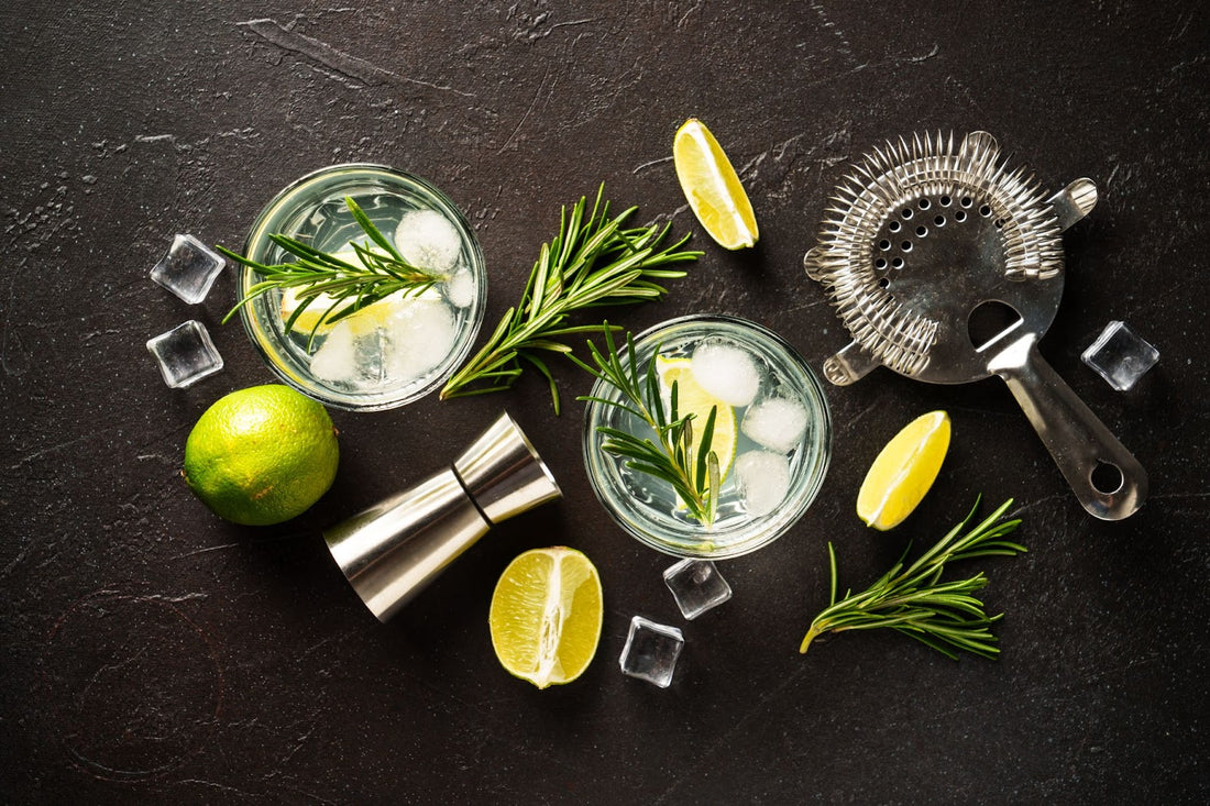 A pair of elegant brandy cocktails, garnished with rosemary and lime.