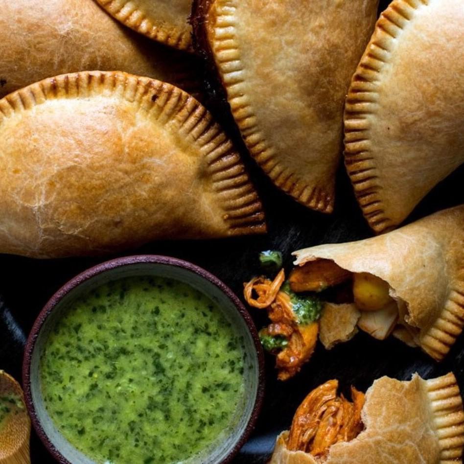 Golden-brown chicken empanada with savory filling, chef-made and ready to serve.